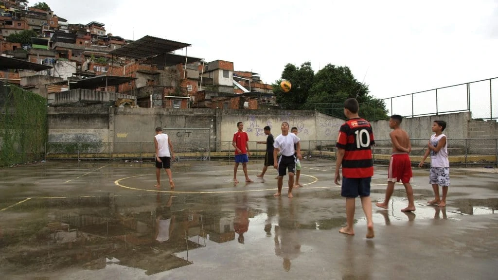 The children in the Brazilian favelas play football with enthusiasm: barefoot on a hard tarred pitch. Hardly any of the money they win at the World Cup goes to them. But they live with the numerous risks of such global sporting events.