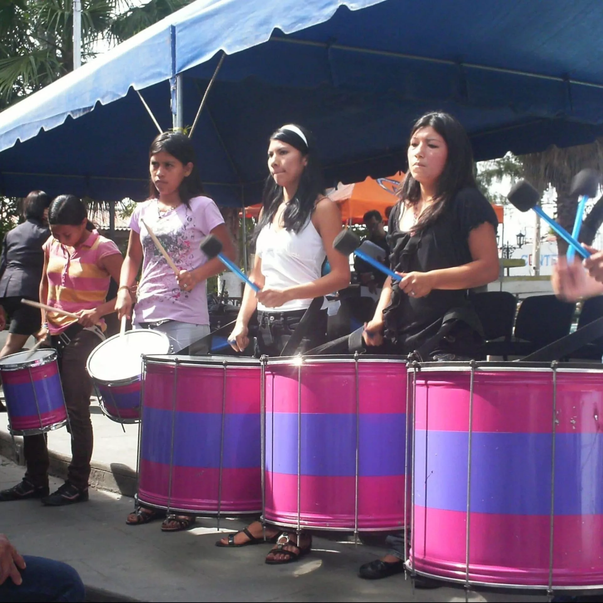 Junge Frauen von Las Melidas schlagen auf grossen Trommeln an einer öffentlichen Kundgebung.