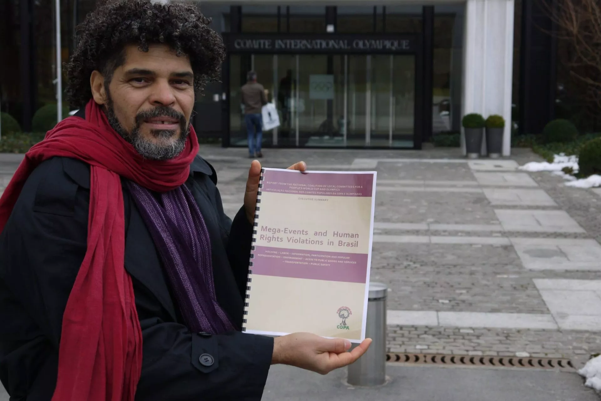 Argemiro vor dem Eingang zum Internationalen Olympischen Komitee. Er hält einen Bericht mit dem Titel: Mega-Events and Human Rights Violations in Brasil.