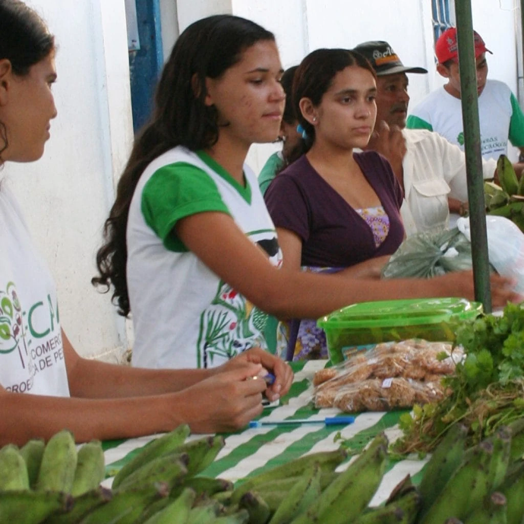 Junge Frauen verkaufen am Marktstand ihre eignen Bananen.