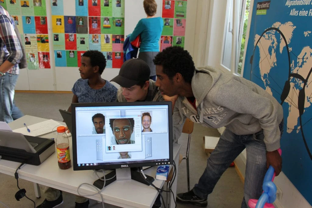 Young asylum seeker at the computer with photos