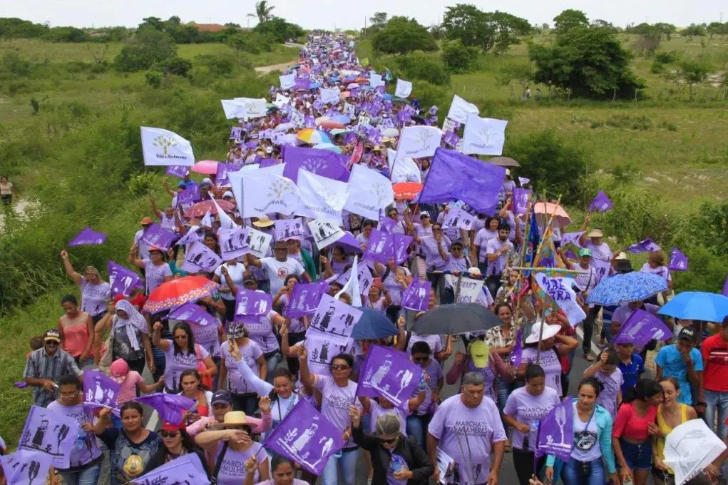 5000 Menschen in violetten Kleidern laufen eine lange Strasse entlang.