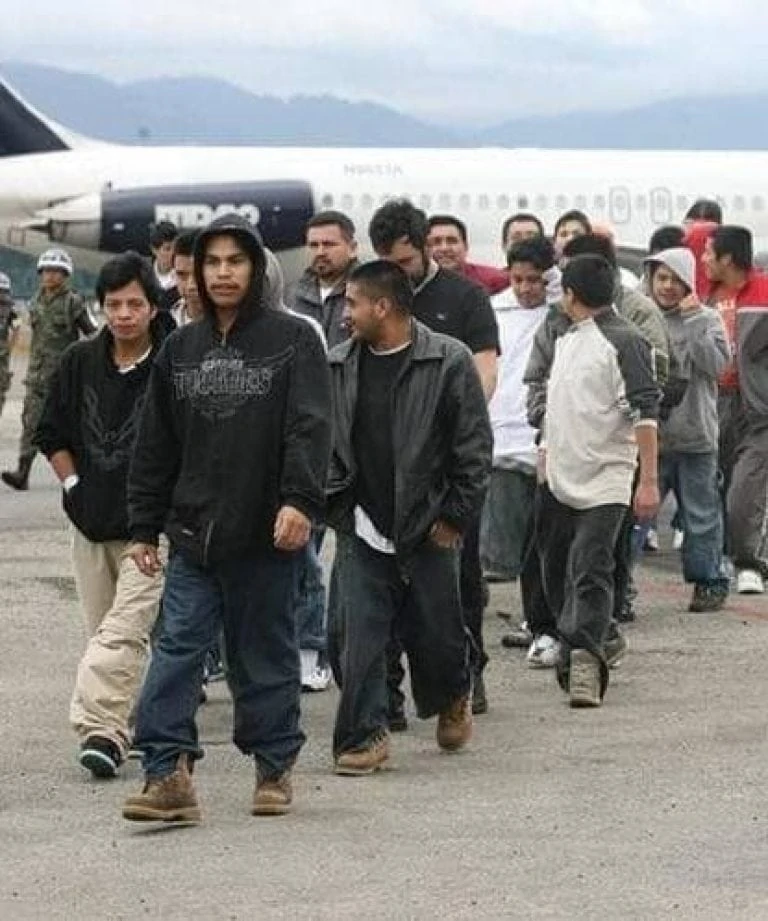 Young Latin American men in front of a plane. They run in a line.