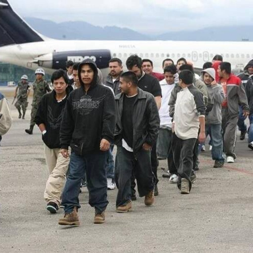 Junge lateinamerikanische Männer vor einem Flugzeug. Sie laufen in einer Reihe.
