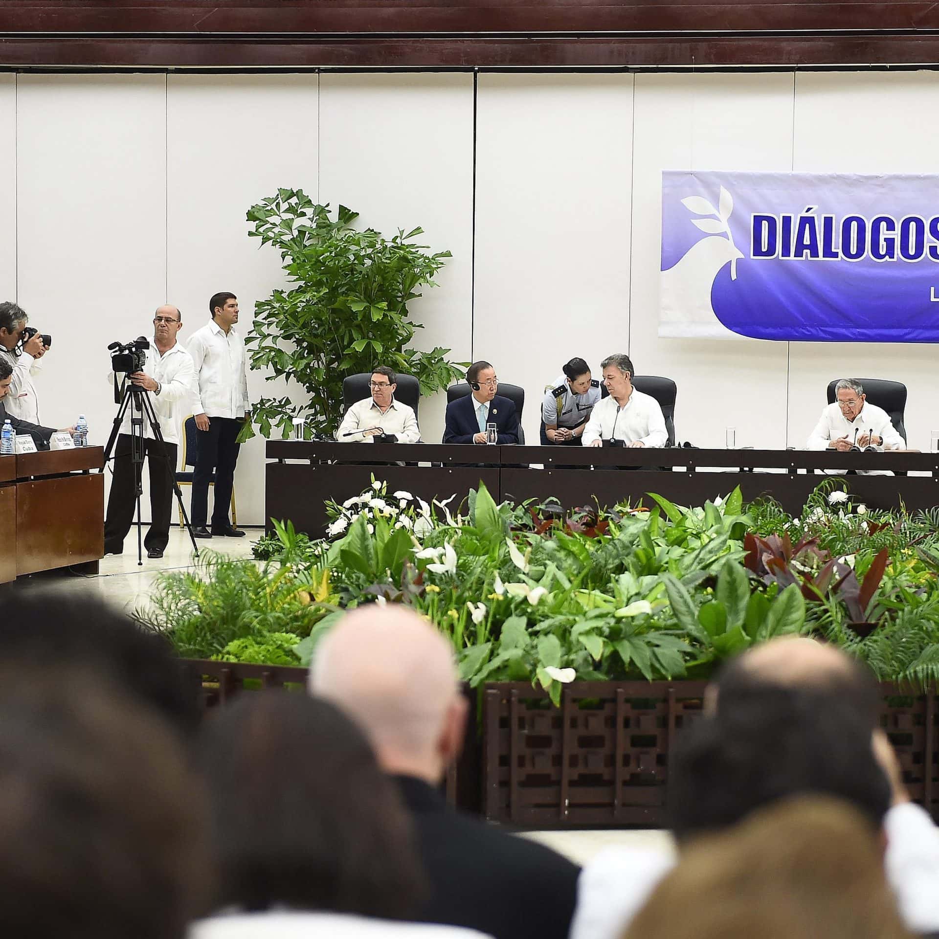 Männer mit weissen Hemden sitzen an einem langen Konferenztisch.