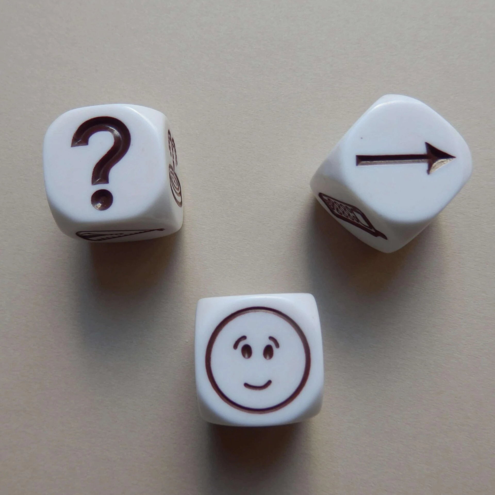 Three white cubes with one black icon each: a question mark, a smiley face and an arrow pointing to the right.