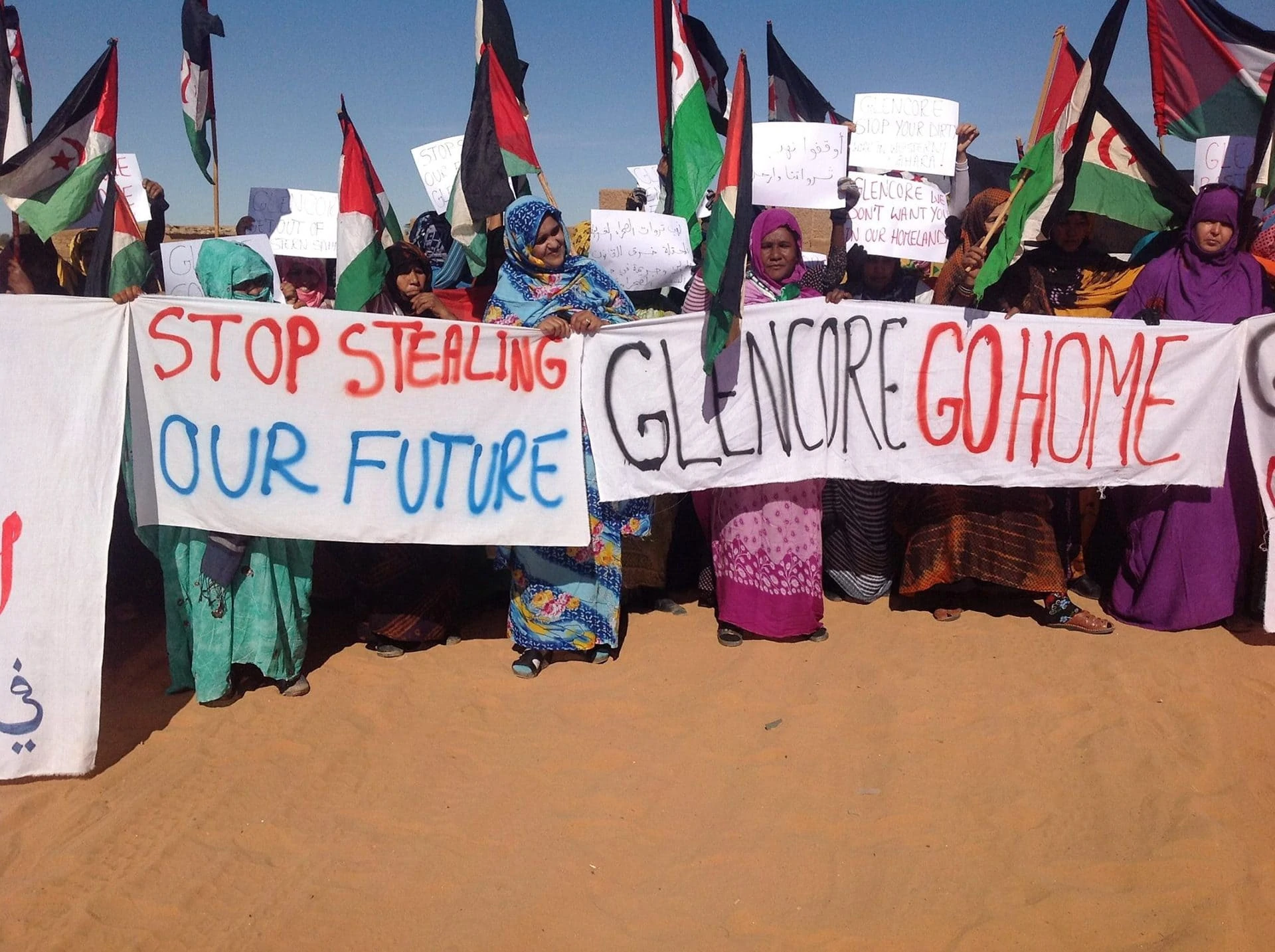 Sahraouis demonstrieren mit Transparenten: Glencore go home!