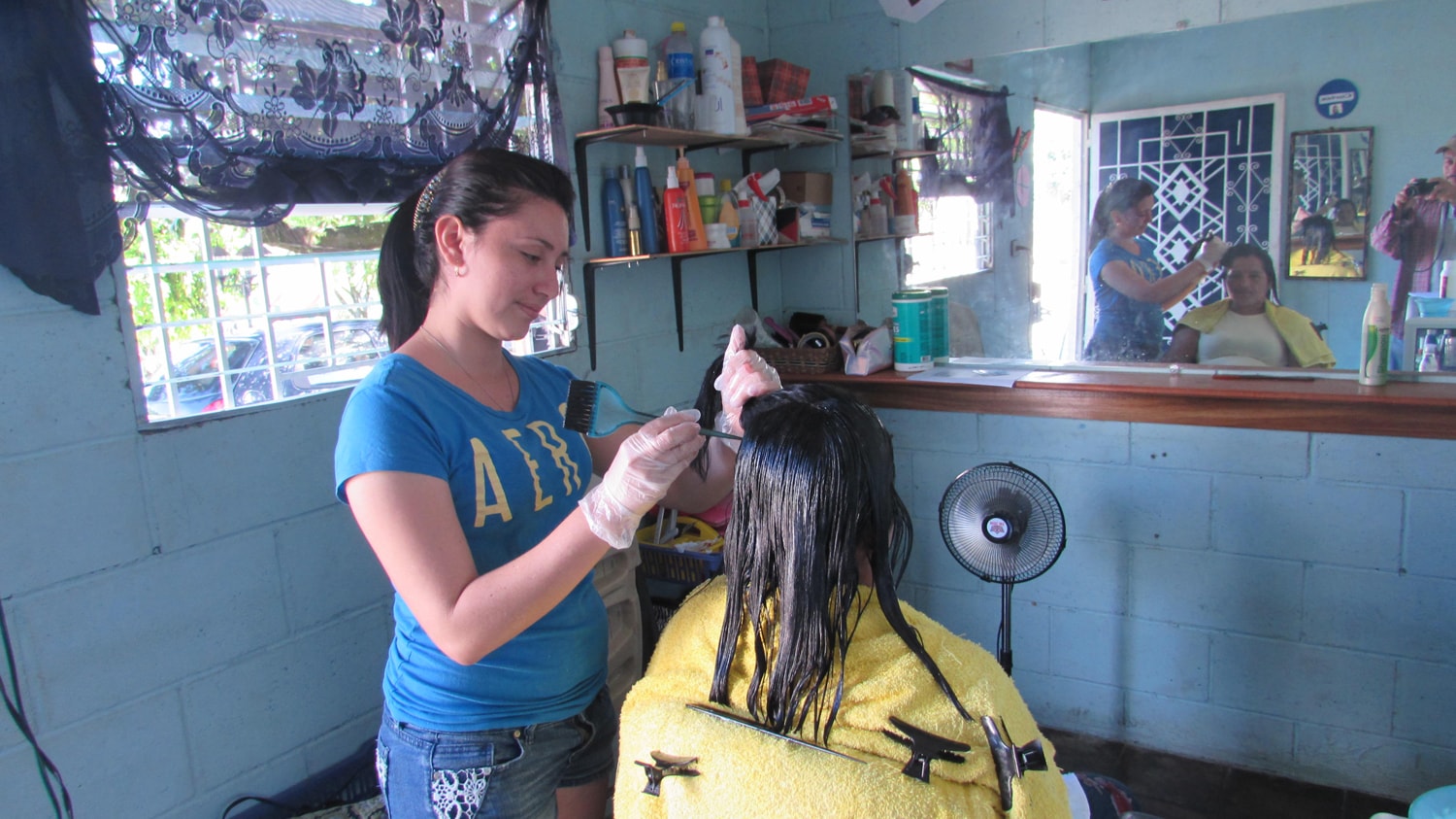 A young woman dyes hair in a hair studio.