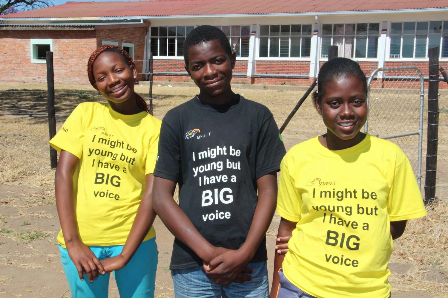 Three teenagers with black and yellow T-shirts. Print: I might be young but I have a BIG voice.