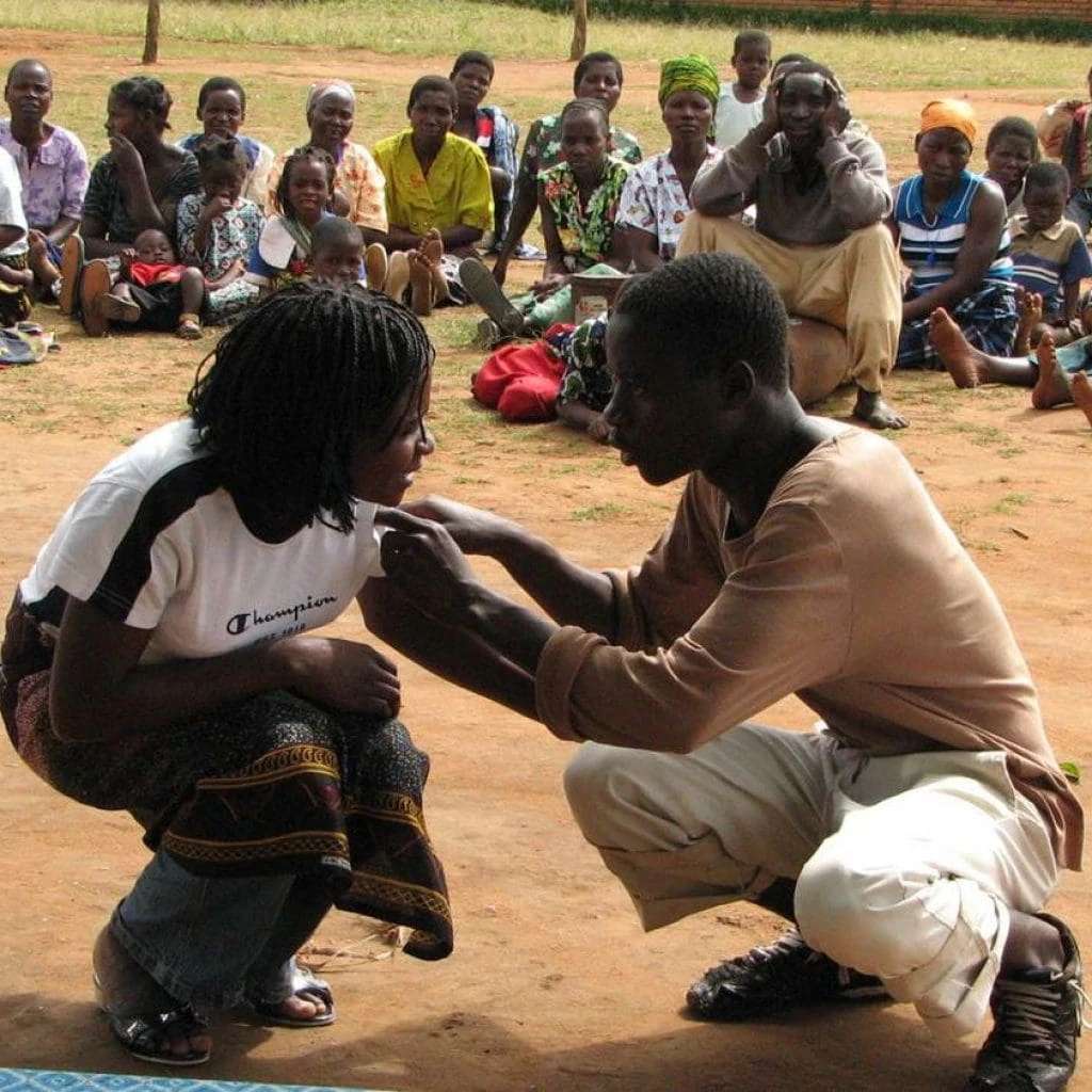 Two young people perform a theatre scene in front of an audience.