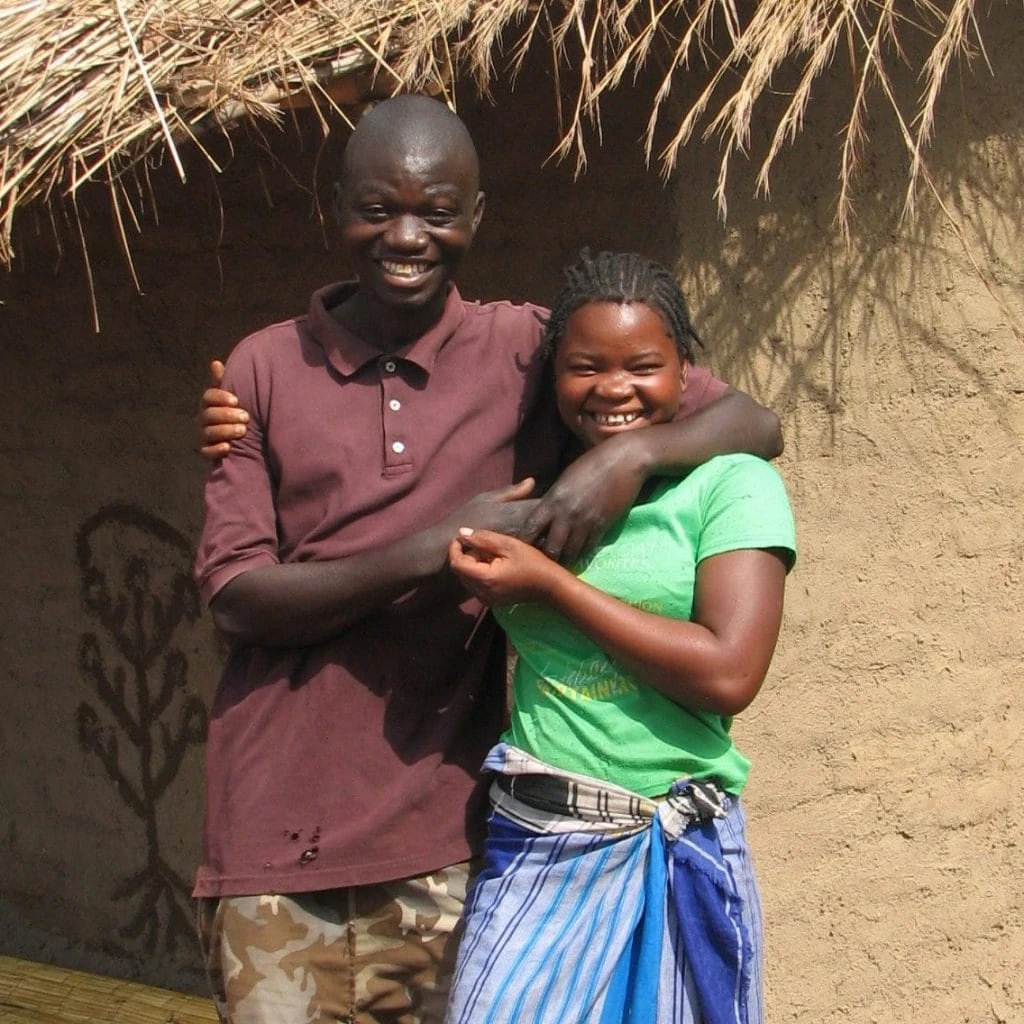 A young couple from Mozambique in front of their own house.