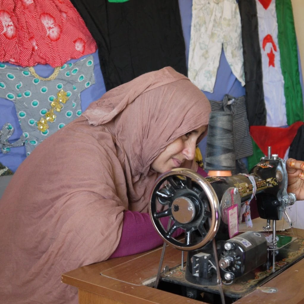 Junge Frau vor manuell betriebener Nähmaschine im Lager Smara.