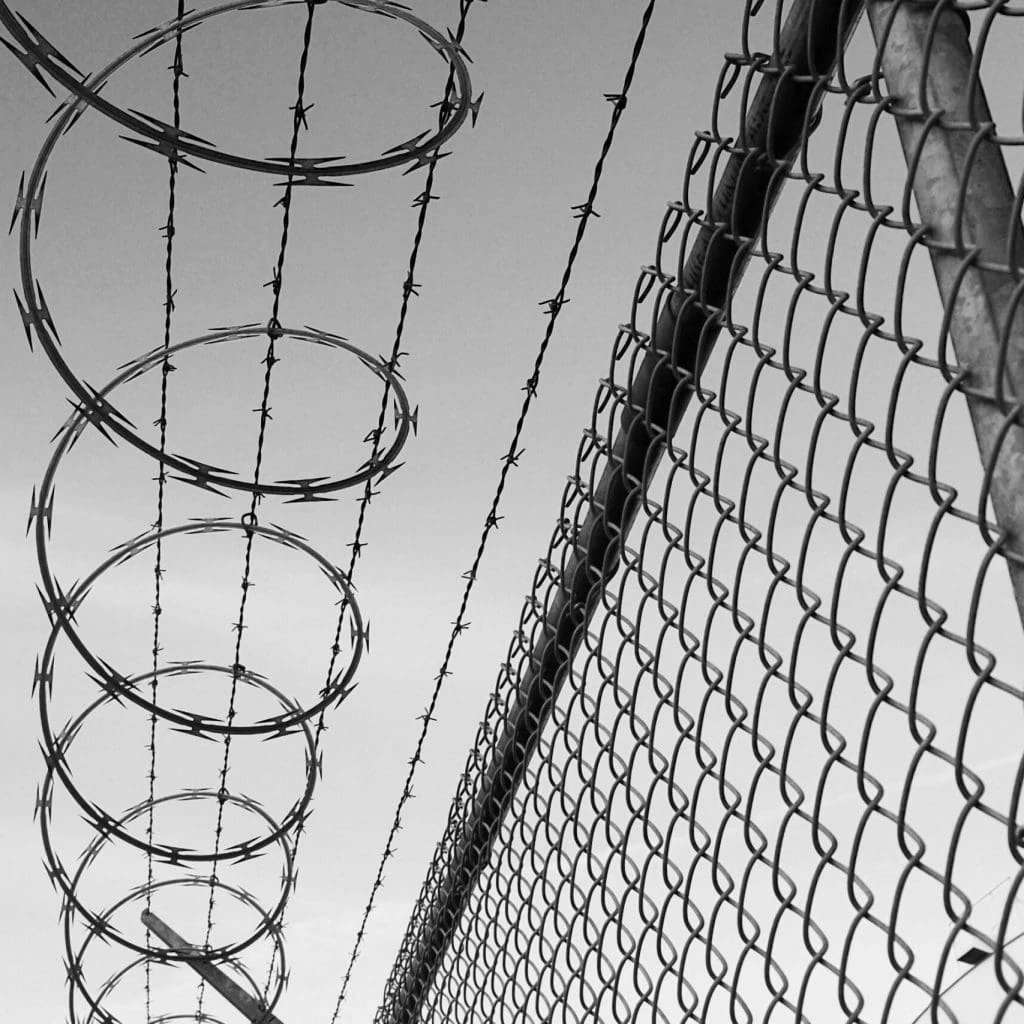 Barbed wire and wire fence black and white with sky