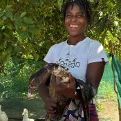 Junge Bäuerin mit Ente im Arm - Hochformat - terre des hommes schweiz