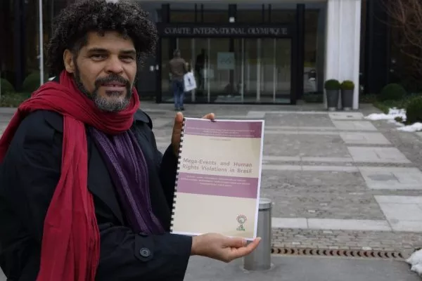 Argemiro at the entrance to the International Olympic Committee. He is holding a report entitled: Mega-Events and Human Rights Violations in Brazil.