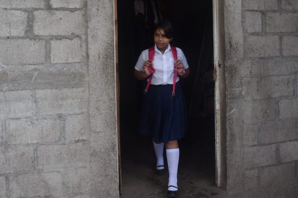 Ein-Mädchen-in-Schuluniform-steht-in-einer-Türöffnung.