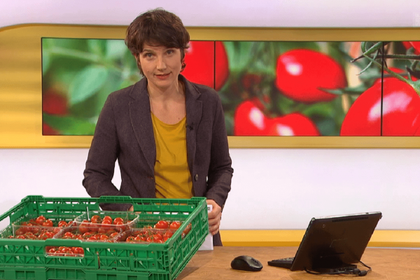 Screenshot aus der Sendung Kassensturz. Die Moderatorin hat Tomaten auf dem Tisch.