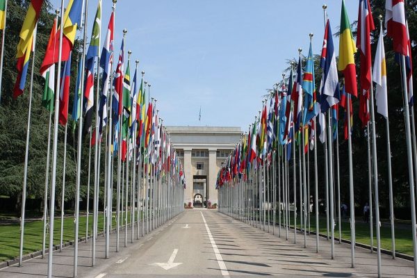 The main building with an avenue full of national flags.